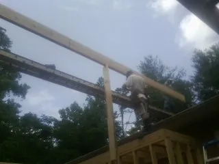 Carpenter setting a ridge beam over a new addition frame — Ice Dam Removal by Roofing Brothers in Jeffersonville